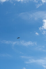 The airplane flies against the background of clouds in the blue sky