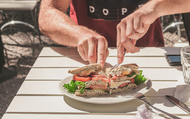 man cutting sandwich 