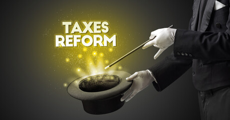 Illusionist is showing magic trick with TAXES REFORM inscription, new business model concept