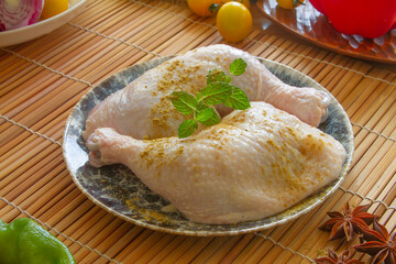 Raw chicken leg quarters with species close up in a bowl