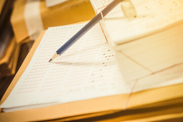 Fototapeta premium Exam tools, including pencils, erasers, and exam papers are on the tables in the exam hall.