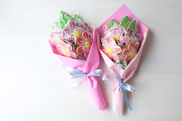 Gingerbreads in the form of pink flowers on the white background. Two bouquets.