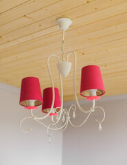 lamp on ceiling. pink chandelier on the wooden ceiling