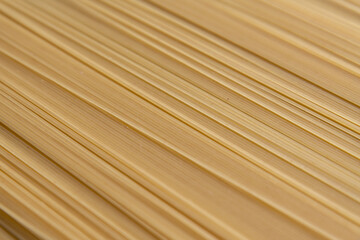 Abstract food background of raw uncooked spaghetti pasta made from milled durum wheat. Selective focus. Copy space for your text. Italian cuisine theme.