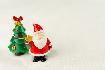 Merry Christmas and happy new year concept. Cute santa claus figure and tree on snow with copy space