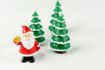 Merry Christmas and happy new year concept. Cute santa claus figure and tree on snow with copy space