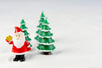 Merry Christmas and happy new year concept. Cute santa claus figure and tree on snow with copy space