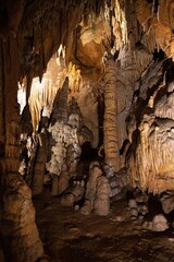 Cavern with stalactites and stalagmites with some light and dark areas