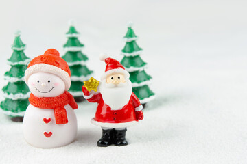 Merry Christmas and happy new year concept. Cute santa claus figure and tree on snow with copy space