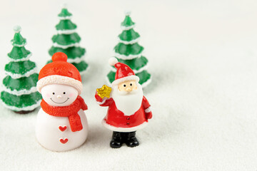 Merry Christmas and happy new year concept. Cute santa claus figure and tree on snow with copy space