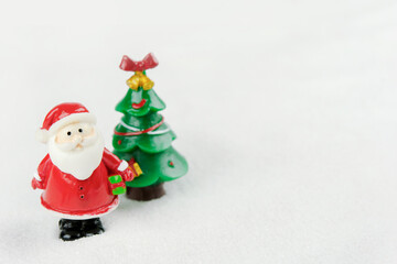 Merry Christmas and happy new year concept. Cute santa claus figure and tree on snow with copy space
