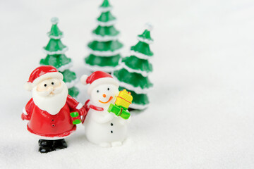 Merry Christmas and happy new year concept. Cute santa claus figure and tree on snow with copy space