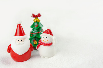 Merry Christmas and happy new year concept. Cute santa claus figure and tree on snow with copy space