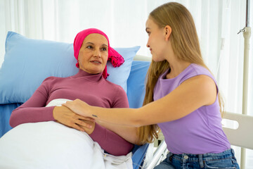 Fototapeta premium Caucasian senior woman with breast cancer patient lying on hospital bed with young european daughter supporting 