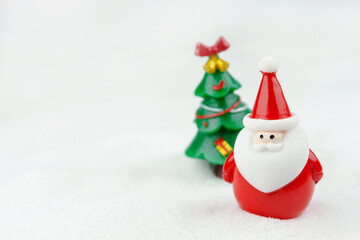 Merry Christmas and happy new year concept. Cute santa claus figure and tree on snow with copy space