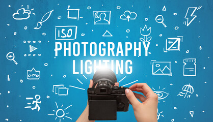 Hand taking picture with digital camera and PHOTOGRAPHY LIGHTING inscription, camera settings...