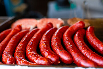 Juicy appetizing grilled sausages in a metal tray. Street food counter