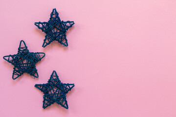 decor in blue in the shape of stars on an isolated pink background with place for text