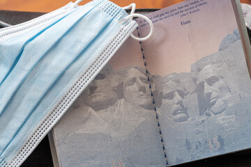 Covid 19 face mask sitting on an blank passport page showing no travel