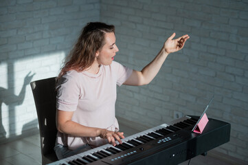 Obraz na płótnie Canvas Female singing teacher at online lesson on digital tablet