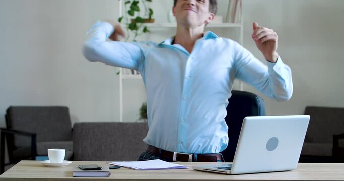 Serious focused young business man writer in blue shirt sits at table, writes letter with pen, signs document agreement order, makes mistake on paper, gets angry tears throws note, concept of failure