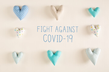 Fight Against Covid-19 message with blue heart cushions on a white paper background