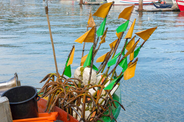 Fototapeta na wymiar buoys, flags and anchors on the bow of a boat in Setubal, Portugal