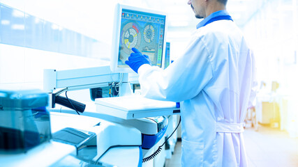 Laboratory assistant in rubber gloves working with a modern immunochemistry analyzer