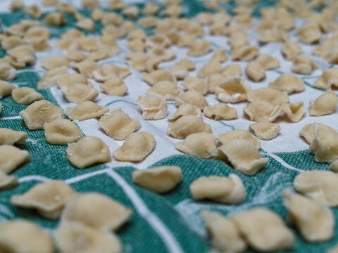 Dinner Time At Home With The Family. On A Tablecloth Numerous Orecchiette, A Typical Product Of Southern Italian Cuisine.