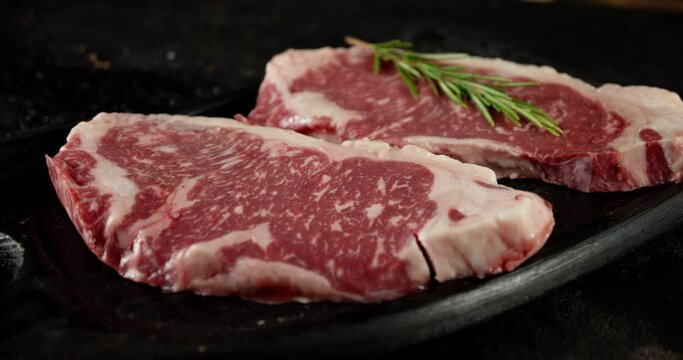 The steak ribeye raw beef on the table slowly rotate. 