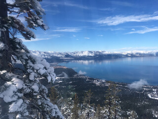 Aerial view of Lake Tahoe on a sunny winter day, with vivid blue skies, as seen from inside a gondola