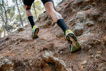 Piernas de un corredor subiendo por una cuesta en la monta&ntilde;a