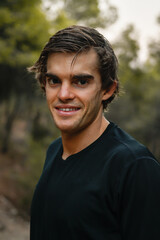 Retrato de joven atleta sonriendo, girado mirando de frente en el campo