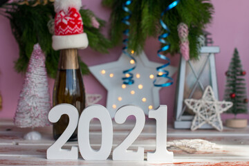 New 2021 year of the ox toy serpentine. Christmas atmosphere decorated Christmas tree on a pink background and a festive bottle of alcoholic champagne