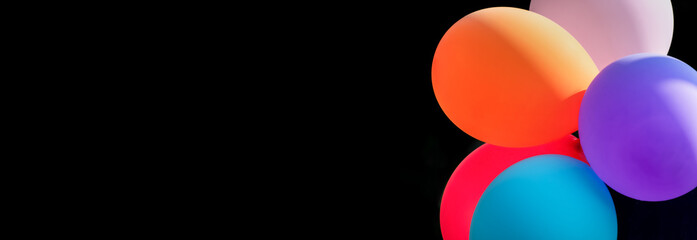 Bunte Luftballons vor schwarzem Hintergrund