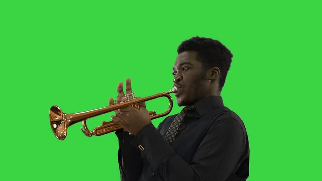 African american musician playing the trumpet expressively on a Green Screen, Chroma Key.