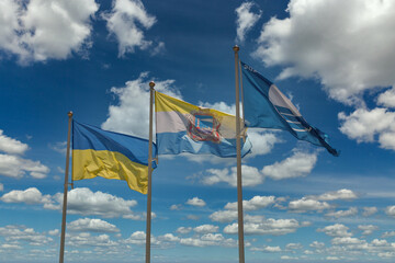 Flags of Ukraine, Chornomorsk and Blue flag 2020 waving against blue sky with clouds