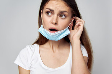 Brunette putting on a medical mask on her face look towards emotions 