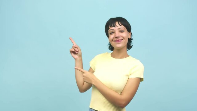 Young caucasian woman pointing to the side, smiling surprised presenting something, natural and casual
