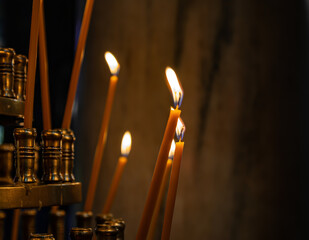 Offering of lit candles in a church in half light