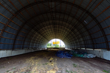 Old empty abandoned rusty metal arched hangar