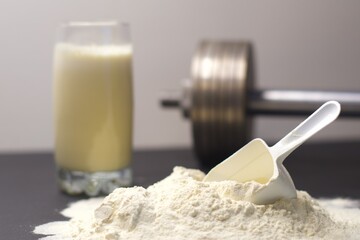 Scoop of whey protein, sports nutrition, supplement, dumbbell and a glass with a cocktail for gain muscles