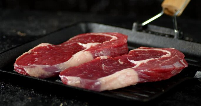 Steak raw beef ribeye in a frying pan.