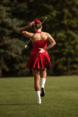 Young majorette throwing stick from hand to hand in the park