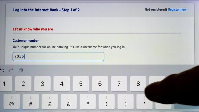 Closeup POV shot of a finger entering the customer number for online banking (no bank logos or branding), on the touch screen keypad of a tablet computer.