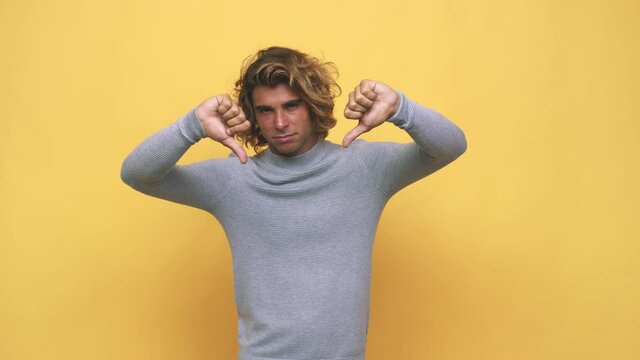 Young cool australian man showing thumb down and expressing dislike
