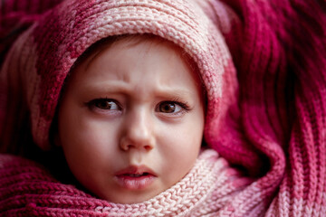 close-up portrait of a girl wrapped in a scarf.