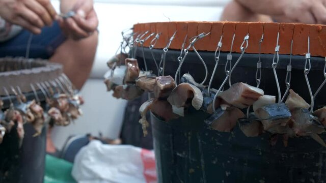 Fishing at the sea. Two fishermen in a boat are baiting fishing hooks. Close-up of pangan and fishing hooks with bait