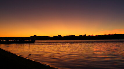 Colourful winter sunset in July, with silhouette and reflection over the Noosa River, Noosaville, Queensland, Australia