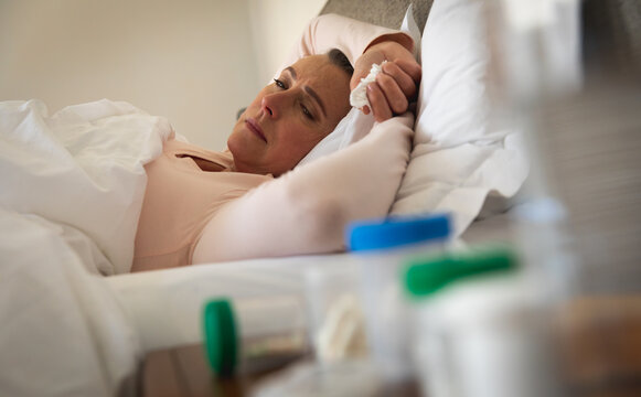 Sick woman with tissue sleeping on the bed